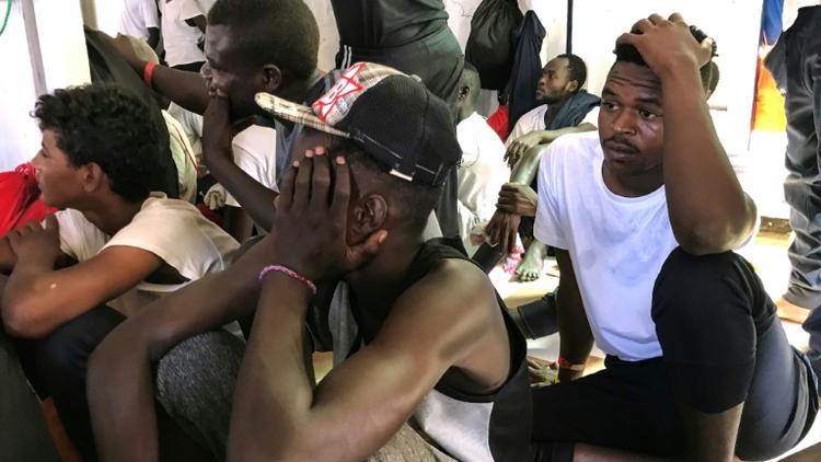 Des migrants secourus par le navire Ocean Viking en Méditerranée attendent à  bord, le 21 août 2019 [Anne CHAON / AFP]