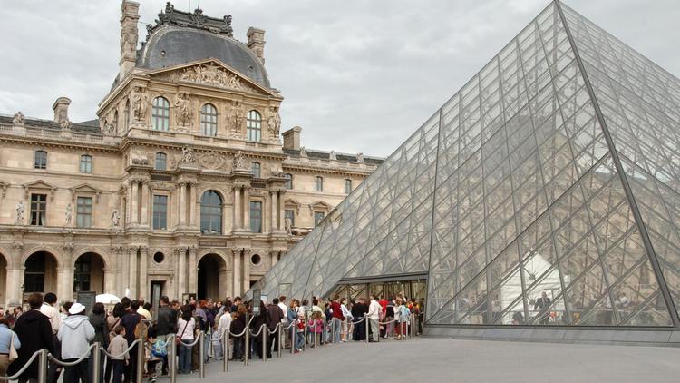 File d'attente de visiteurs à l'entrée du musée du Louvre à Paris.