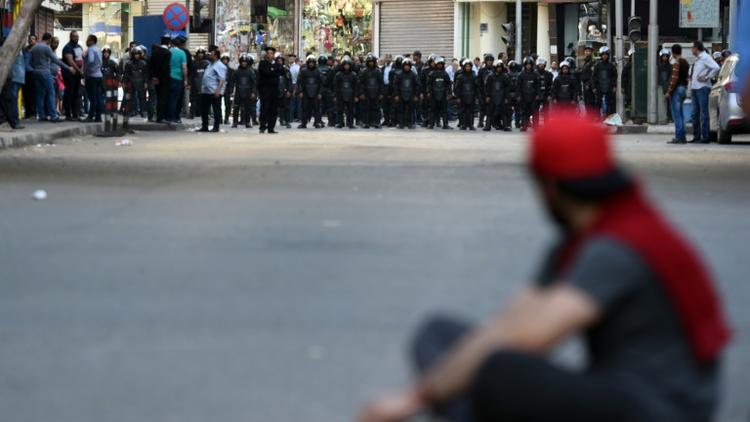 Un homme face aux forces de sécurité pendant une manifestation, le 15 avril dans le centre du Caire, appelant à la "chute du régime" du président Sissi [MOHAMED EL-SHAHED / AFP/Archives]