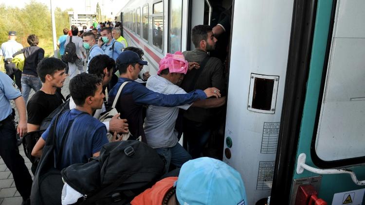 Des migrants et réfugiés montent dans un train à la gare d'Ilaca, le 17 septembre 2015 en Croatie, près de la frontière avec la Serbie [ELVIS BARUKCIC / AFP]