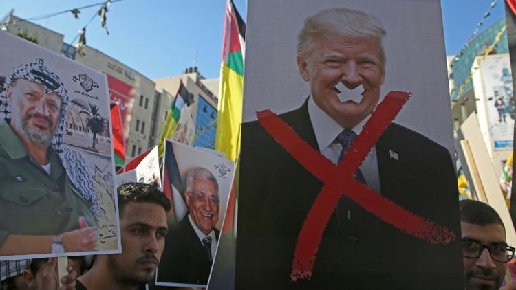 Des manifestants palestiniens avec des portraits de l'ancien leader palestinien Yasser Arafat et du président américain Donald Trump lors d'un rassemblement dans la ville de Naplouse, en Cisjordanie occupée, le 18 juillet 2018 [Jaafar ASHTIYEH / AFP/Archives]