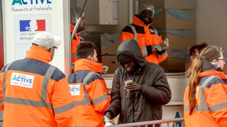 Des bénévoles de l'association La Vie Active distribuent des repas à des migrants à Calais, le 6 mars 2018 [PHILIPPE HUGUEN / AFP]