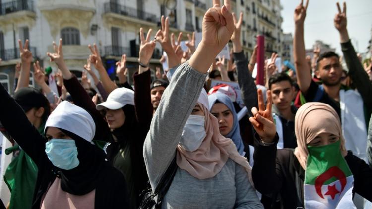Des manifestants algériens font le V de la victoire lors d'une manifestation anti-gouvernementale à Alger le 23 avril 2019 [RYAD KRAMDI                         / AFP/Archives]