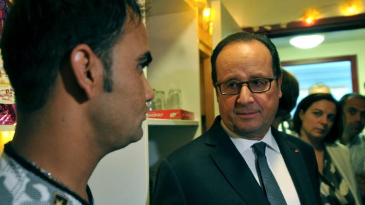 François Hollande avec un Afghan lors d'une visite dans un centre d'accueil et d'orientation (CAO) le 24 septembre 2016 à Tours [GUILLAUME SOUVANT / POOL/AFP]