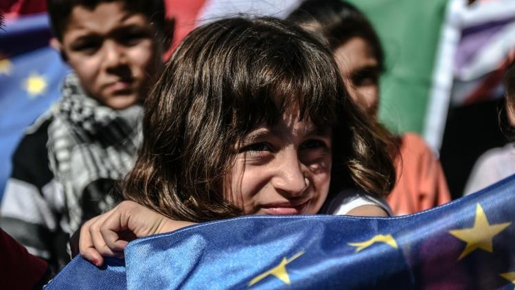 Une jeune migrante brandit un drapeau européen lors d'une manifestation de réfugiés à Istanbul, en Turquie, le 19 septembre 2015 [Ozan Kose / AFP]