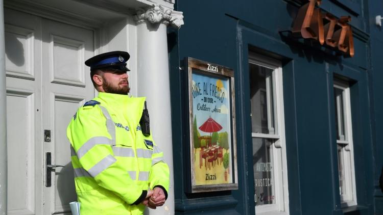 Un policier britannique monte la garde le 6 mars 2018 devant un restaurant de la chaîne Zizzi à Salisbury, fermé en lien avec un mystérieux empoisonnement présumé d'un ex-espion russe [Chris J Ratcliffe / AFP]
