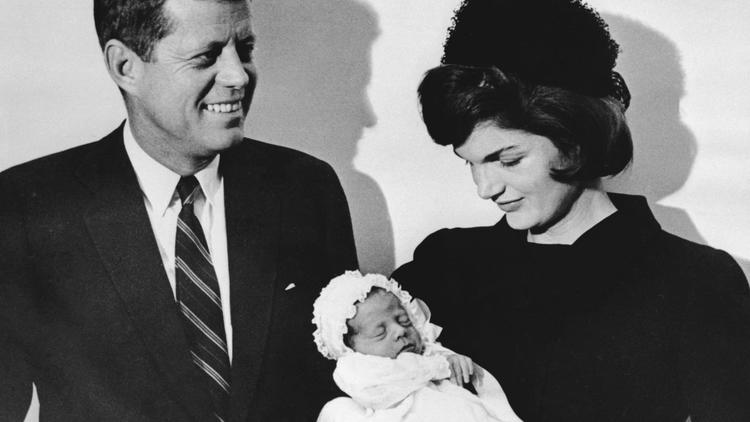 John F. Kennedy, sa femme Jackie avec leur fils John F. Kennedy lors du baptême de ce dernier, le 10 décembre 1960 à la chapelle de l'Université de Georgetown [Sam Schulman / AFP]