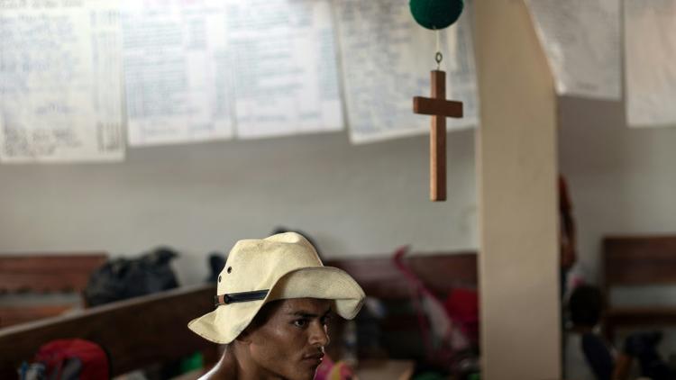 Un participant à la caravane de migrants partie du Honduras en mars pour rallier laes Etats-Unis se repose dans une église de Tapanatepec (sud du Mexique) le 27 octobre 2018 [Guillermo Arias / AFP]