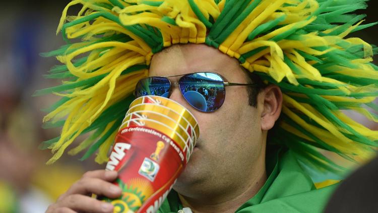 Un supporter boit un verre de bière avant le coup d'envoi du match de Coupe des Confédérations 2013 entre le Japon et le Mexique à Belo Horizonte le 22 juin 2013  [Yuri Cortez / AFP/Archives]