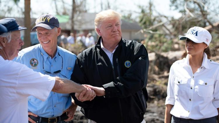 Le président américain Donald Trump (au centre), avec sa femme Melania à ses côtés et le gouverneur de Floride Rick Scott (à gauche) constatent les dégâts après le passage de l'ouragan Michael, à Lynn Haven, le 15 octobre 2018 [SAUL LOEB / AFP]