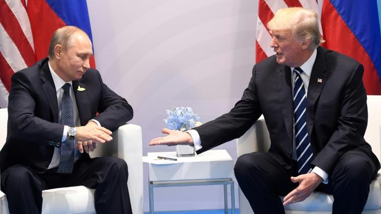 Le président américain Donald Trump tend la main à son homogue russe Vladimir Poutine lors du sommet du G20 à Hambourg en Allemagne, le 20 juillet 2017  [SAUL LOEB / AFP/Archives]