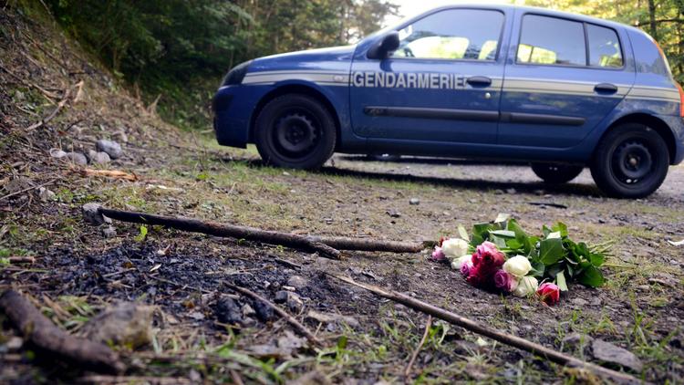 Un bouquet de roses à proximité d'un véhicule de gendarmerie sur les lieux de la tuerie de Chevaline, le 8 septembre 2012 [Philippe Desmazes / AFP/Archives]