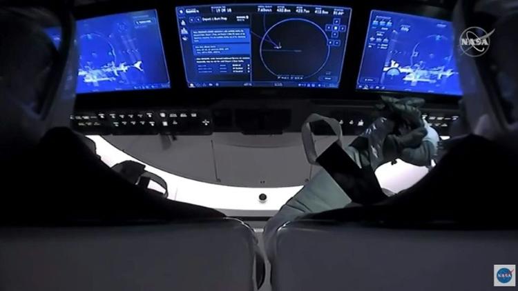 Image diffusée par la Nasa des astronautes américains Doug Hurley et Robert Behnken à bord de la capsule Crew Dragon de SpaceX après leur désarrimage de l'ISS, le 1er août 2020 [Handout / NASA TV/AFP]