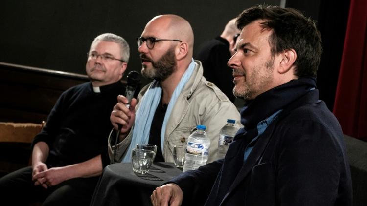 Le Père Yves Baumgarten (G), le président de l'association "La Parole Libérée", Francois Devaux (c) et le metteur en scène François Ozon (D)lors d'un débat le 6 avril 2019 à Lyon [JEFF PACHOUD / AFP]