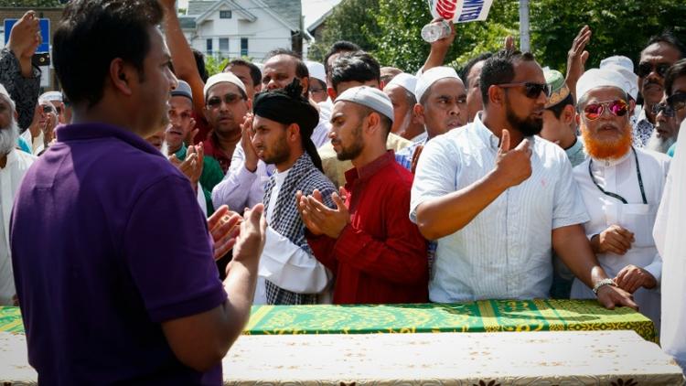Des hommes prient autour des cercueils contenant les corps d'un imam et de son assistant tués par balles, à New York le 15 août 2016 [KENA BETANCUR / AFP]