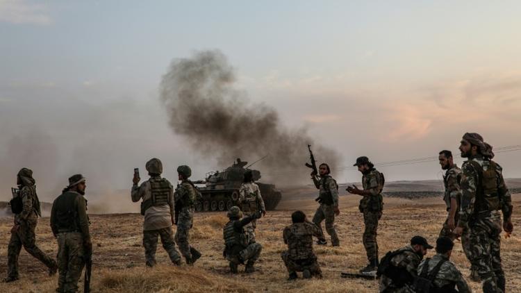 Des soldats turcs et des combattants syriens alliés se rassemblent sur les abords de la ville de Minbej, dans le nord de la Syrie, près de la frontière turque, le 14 octobre 2019 [Zein Al RIFAI / AFP]