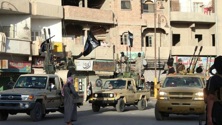 Photo diffusée sur le site jihadiste Welayat Raja, le 30 juin 2014, montant des jihadistes du groupe Etat islamique paradant dans une rue de Raqa, en Syrie [- / WELAYAT RAQA/AFP/Archives]