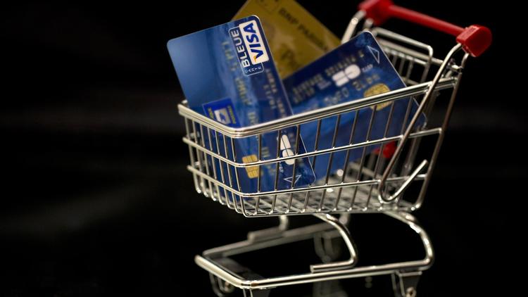 Photo de cartes de crédit dans un charriot de supermarché miniature [Joel Saget / AFP]