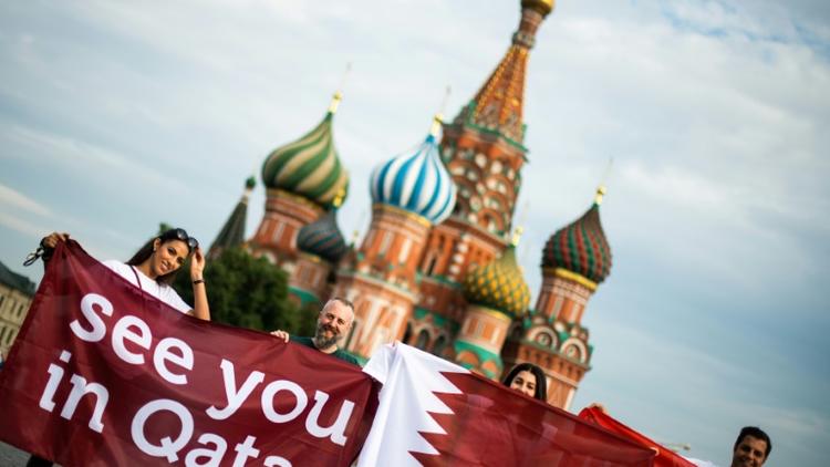 Des personnes déploient une banderole "à bientôt Qatar" sur la Place Rouge de Moscou, à la veille de la finale du Mondial-2018 en Russie, le 14 juillet 2018 [Jewel SAMAD / AFP/Archives]