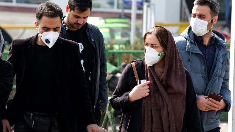 Des piétons, certains portant un masque de protection, dans une rue de Téhéran, le 22 février 2020 en Iran [ATTA KENARE / AFP]