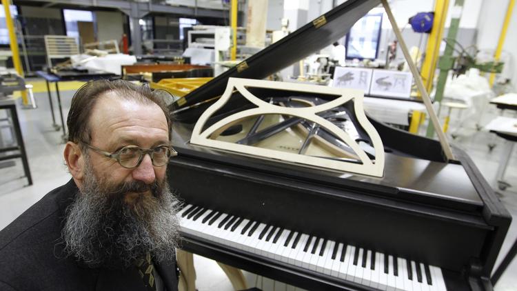 Le designer italien Michel de Lucchi pose le 3 décembre 2010 en face d'un piano qu'il a dessiné pour Pleyel [Francois Guillot / AFP/Archives]