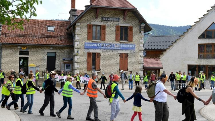 Environ 300 personnes ont formé une chaîne humaine le 5 mai 2018 dans le village d'Autrans (Isère) pour protester contre les compteurs communicants Linky [JEAN-PIERRE CLATOT / AFP]