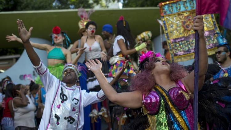 Des danseurs lèvent les bras au ciel au sein du cortège "Loucura suburbana", pendant le carnaval de Rio, le 8 février 2018 [MAURO PIMENTEL / AFP]