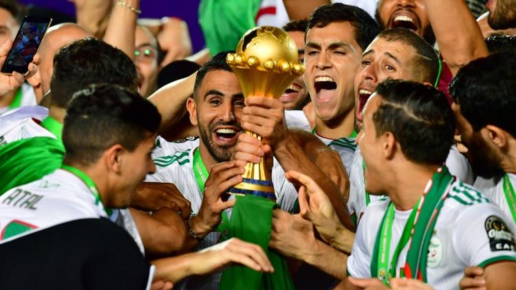 L'attaquant Riyad Mahrez (c) soulève le trophée après la victoire de l'équipe d'Algérie contre le Sénégal en finale de la CAN-2019, le 19 juillet 2019 au Caire [Giuseppe CACACE / AFP]
