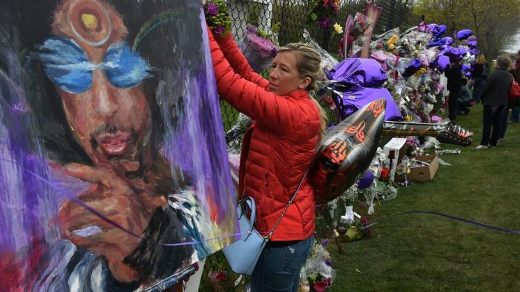 Une fan attache des fleurs en hommage à Prince à Minneapolis, le 22 avril 2016 [Mark Ralston / AFP]