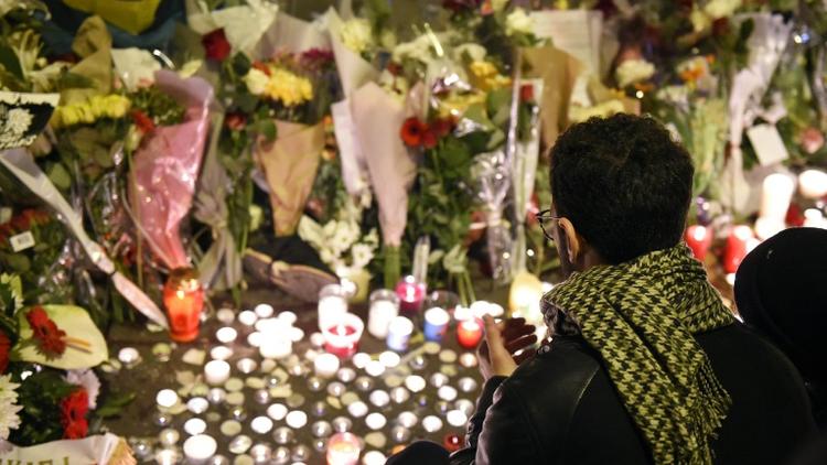 Un homme rend hommage aux victimes des attaques du Bataclan, le 14 novembre 2015 à Paris [FRANCK FIFE / AFP]