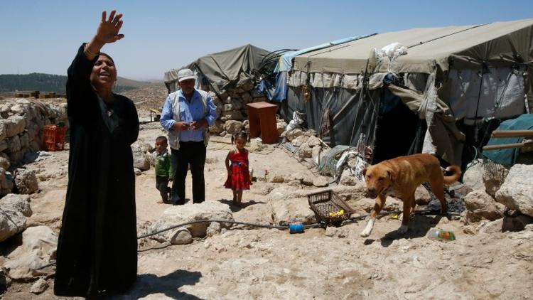 Shafiq al-Tal (c) entouré de sa famille est devant sa tente dans le village palestinien de Khirbet Zannouta, près de Hébron, le 30 mai 2016  [HAZEM BADER / AFP]