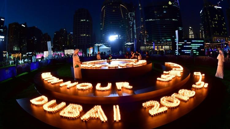 A Dubai, des gens ont allumé des bougies alors que les gratte-ciel s'étaignaient le 24 mars 2018 à l'occasion d'Earth Hour. [Giuseppe CACACE / AFP]