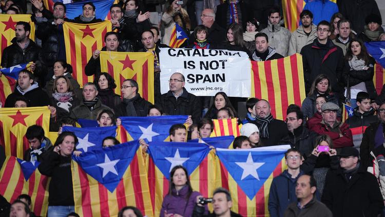 Des partisans de l'indépendance de la Catalogne vis-à-vis de l'Espagne brandissent des drapeaux catalans et des pancartes lors d'un match de football opposant la Catalogne au Cap Vert au stade Lluis Companys Olympic de Barcelone, le 30 décembre 2013 [Josep Lago / AFP/Archives]