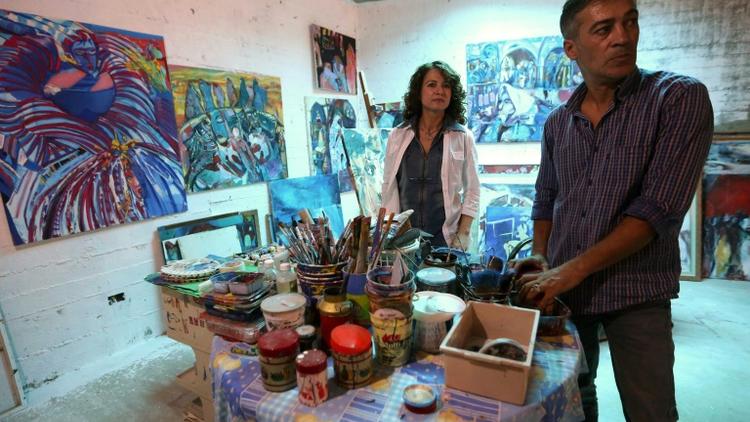 L'artiste peintre libyenne, Najla al-Fitouri, et son mari le peintre Youssef Ftis dans leur atelier à Tripoli, le 12 septembre 2015 [MAHMUD TURKIA / AFP]