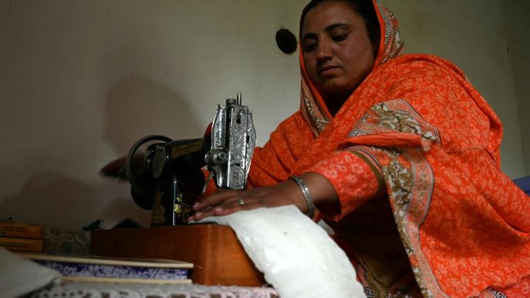 Hajra Bibi coud des serviettes hygiéniques, le 18 mai 2019 dans le village pakistanais de Booni [AAMIR QURESHI / AFP]