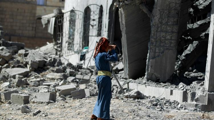 Un homme se tient devant un immeuble détruit par un bombardement de la coalition menée par l'Arabie saoudite, à Sanaa le 28 octobre 2015 [MOHAMMED HUWAIS / AFP/Archives]