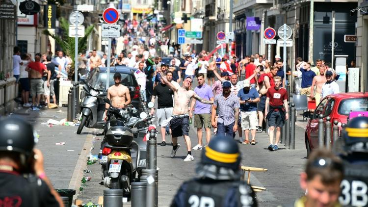 Des supporters anglais lancent des bouteilles sur les forces de l'ordre le 11 juin 2016 à Marseille [LEON NEAL / AFP]
