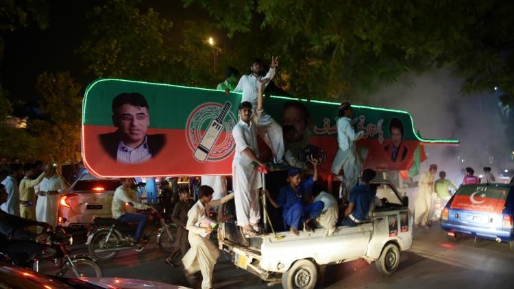 Des partisans de l'ancien champion de cricket Imran Khan, chef du Pakistan Tehreek-e-Insaf (PTI) manifestent leur joie dans une rue d'Islamabad le 25 juillet 2018 [AAMIR QURESHI / AFP]