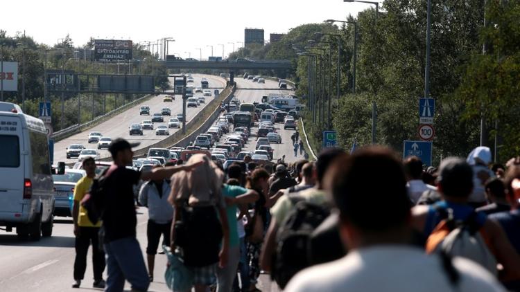 Des migrants partis de la gare de Budapest empruntent à pied une autoroute en direction de l'Autriche, le 4 septembre 2015 [Ferenc Isza / AFP]