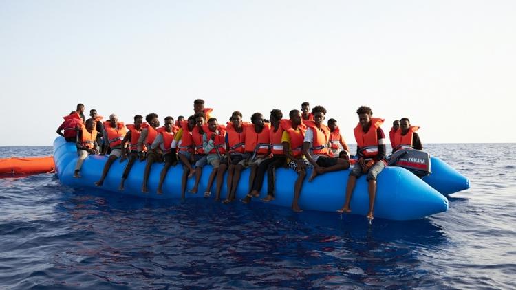 Photo prise et difffusée le 5 juillet 2019 par l'ONG allemande Sea-Eye montrant des migrants à bord d'un canot pneumatique surchargé repéré dans les eaux internationales au large de la Libye [Fabian Heinz / sea-eye.org/AFP/Archives]