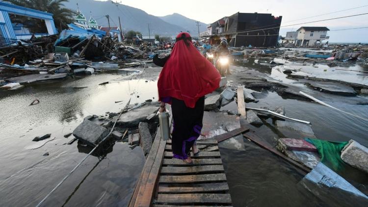 Une femme marche au milieu d'une zone dévastée à Palu le 1er octobre 2018 [Adek BERRY / AFP]