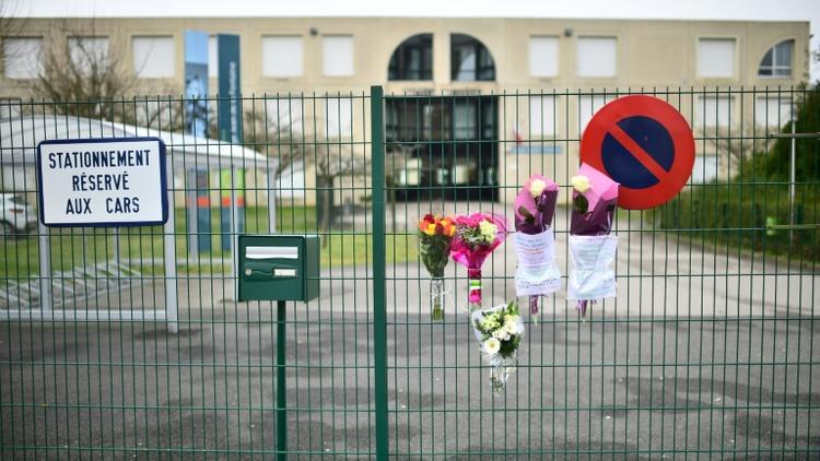 Des fleurs déposées sur la grille du collège Jean de La Fontaine à Crépy-en-Valois (Oise), où travaillait l'enseignant mort du Covid-19 le 26 février à Paris [Martin BUREAU / AFP]
