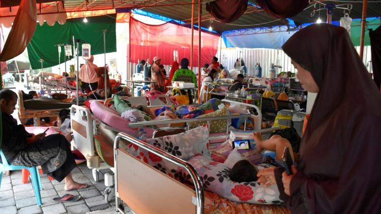 Des blessés et leurs familles dans un hôpital de fortune à Mataram le 20 août 2018, sur l'île de Lombok en Indonésie, touchée par de multiples séismes [STR / AFP]