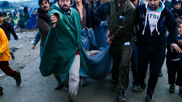 Evacuation d'une femme blessée lors d'une distribution de nourriture le 10 mars 2016 à Idomeni à la frontière de la Grèce et de la Macédoine [DIMITAR DILKOFF / AFP]