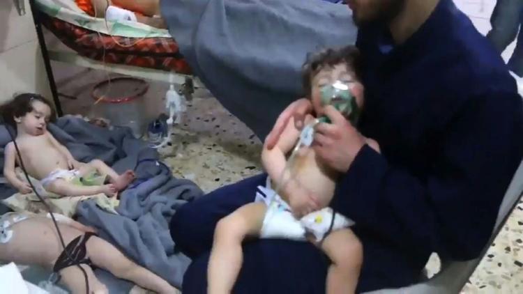 Une image prise sur une vidéo de la Défense civile syrienne montre des volontaires aidant des enfants victimes d'une attaque chimique présumée à Douma, le 8 avril 2018 [HO / AFP]