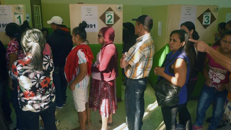 Des Honduriens attendent de recevoir leur carte d'électeur pour voter à la présidentielle, le 25 novembre 2017 à Tegucigalpa [RODRIGO ARANGUA / AFP]