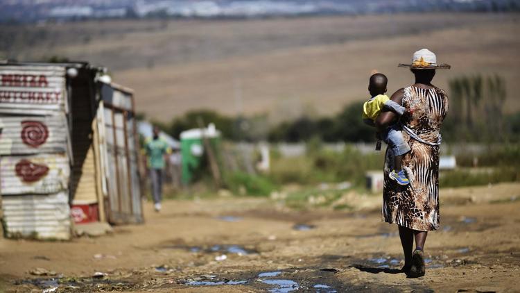 Une femme et son enfant dans un bidonville sur le continent africain, le 24 avril 2014 [Mujahid Safodien / AFP/Archives]