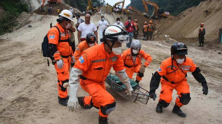 Des équipes de secours transportent le corps d'une victime après un glissement de terrain  à Santa Catarina Pinula, le 6 octobre 2015 au Guatemala [JOHAN ORDONEZ / AFP]