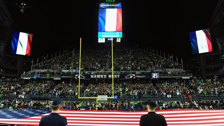 Des drapeaux français sont hissés, le 15 novembre 2015 dans un stade à Seattle en hommage aux victimes des attaques de Paris [Steve Dykes / GETTY IMAGES NORTH AMERICA/AFP]
