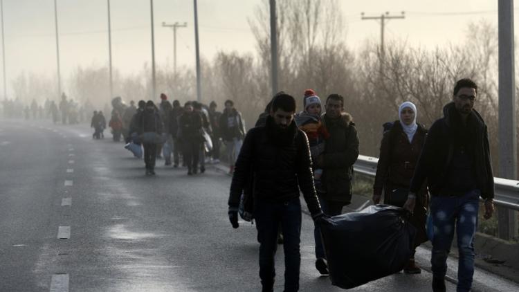 Des migrants et des réfugiés traversent la frontière gréco-macédonienne près du village grec d'Idomeni, le 1er mars 2016 on 1 March, 2016 [SAKIS MITROLIDIS / AFP]